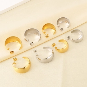 Polished C-shape wide hoop earrings in gold and silver finish on silk background