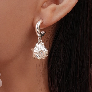 Close-up of starfish and seashell drop earrings worn on ear in silver finish