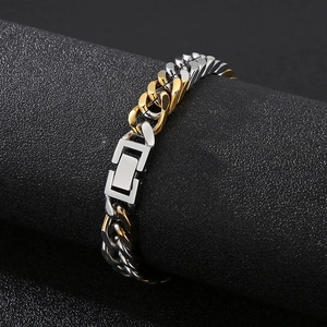 Close-up of gold and silver two-tone Cuban link bracelet on a black display stand