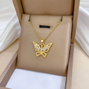 Detailed macro of hollow butterfly pendant with sparkling crystals on gold chain