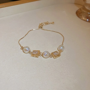 Detail of adjustable gold bracelet featuring iridescent beads and square zircon stones