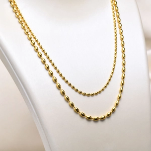 Detail of double-layer gold titanium steel olive bead necklace on a neutral bust model