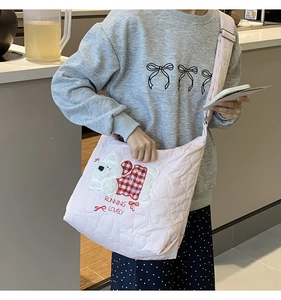 Pink quilted tote bag with cute bear embroidery and text shown on a crossbody model