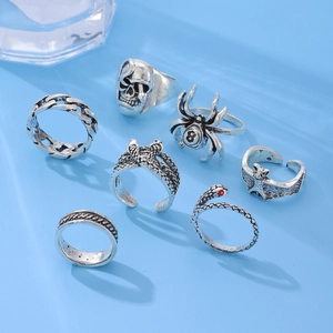 Gothic 7-piece ring set with skull and spider motifs displayed on blue backdrop