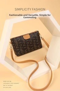 Detail view of printed monogram crossbody bag with golden hardware and brand logo lettering
