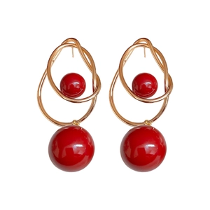 Irregular gold twisted hoop earrings with elegant red pearl beads on white background