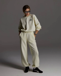 Détail d'un sweat à col rond beige chaud et d'un pantalon de jogging assorti avec bords-côtes