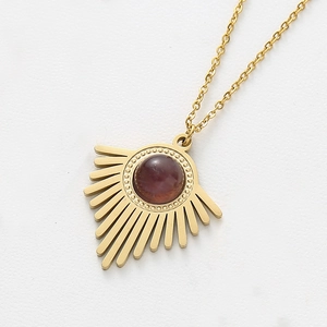 Détail du collier doré avec pendentif soleil et pierre d'améthyste violette