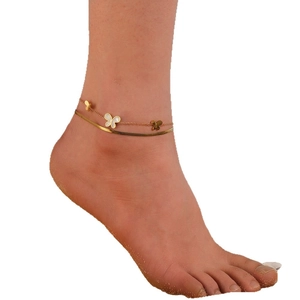 Double-layered gold anklet with white shell butterfly charm on a flat snake chain