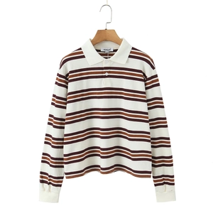 Close-up of polo shirt striped texture and white buttoned collar on wooden hanger
