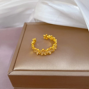 Gold flower open ring with inlaid diamonds displayed on a jewelry box with silk fabric