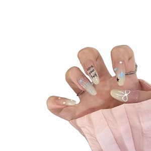 Almond press-on nails with white bow designs, pearls, and starry gradient patterns