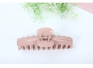 Detail shot of a large glossy pink hair claw clip for thick hair on a white background