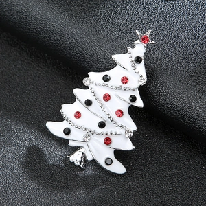 Detailed close-up of a white enamel Christmas tree brooch with colorful rhinestones