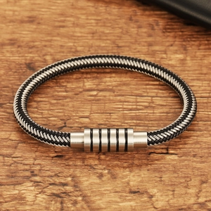 Minimalist woven steel wire bracelet for men with magnetic stainless steel clasp on wood