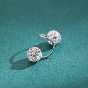 Silver S-shaped geometric ear cuff with sparkling zircon beads on a green textured surface