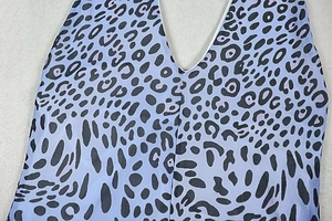 Detail view of the V-neckline and leopard print pattern on light purple fabric