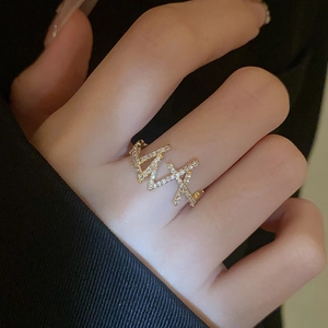 Macro view of double-layered gold ring with crisscross pavé zircon and minimalist geometry