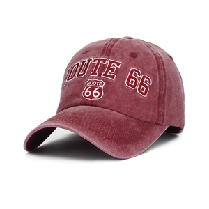 Close-up of vintage Route 66 embroidery on washed red denim baseball cap textures