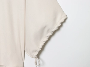 Detailed macro view of beige fabric texture with functional drawstring on trousers