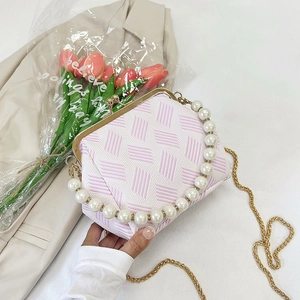 Detail of pink and white woven shell bag with pearl handle and golden chain strap