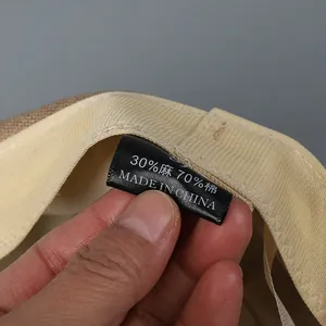 Detail view of cotton linen newsboy hat label showing 30% linen and 70% cotton materials