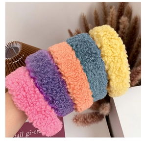 Soft lamb wool headbands in various candy colors being held up against a minimalist background