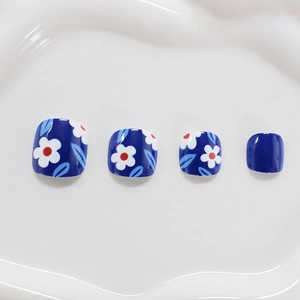 Blue square press-on toenails with white floral designs and minimalist leaf patterns
