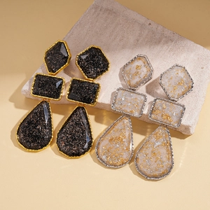 Boucles d'oreilles géométriques en résine noire et ivoire avec détails en feuilles d'or