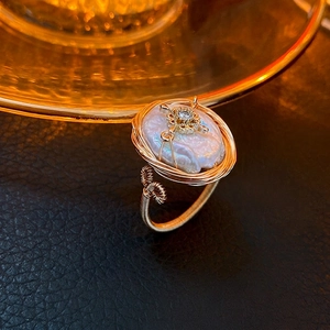 Anello aperto con perla barocca, stella di zirconi e fascia avvolta in filo dorato