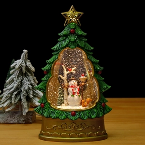 Detail view of a glowing Christmas tree water globe with snowman and squirrel miniatures
