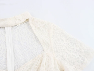 Close-up of white lace dress sweetheart neckline with delicate texture and back zipper
