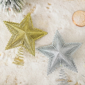 Golden and silver iron wire star tree toppers with glitter on a festive snow background