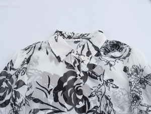 Detail view of vintage floral chiffon blouse featuring elegant black rose patterns and S label
