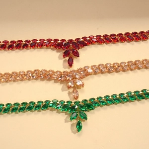 Détail de trois pendentifs épi de blé en cristal rouge, émeraude et doré champagne
