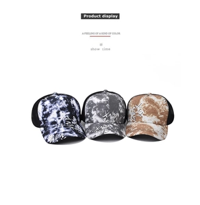 Detailed view of three gradient tie-dye baseball caps with mesh back and GEN embroidery