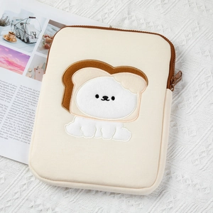 Macro detail of cream padded tablet sleeve with cute toast puppy embroidery and side zipper