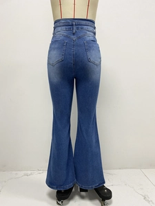 Détail de jean évasé à taille haute avec poches arrière et finition délavée bleue