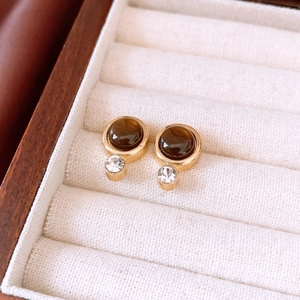 Gros plan de boucles d'oreilles vintage dorées avec œil de tigre et strass cristal