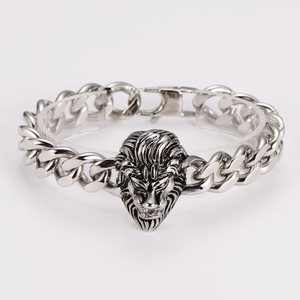 Macro detail of men's chunky Cuban chain bracelet featuring a lion head relief in antique silver