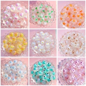 Vue détaillée de perles en acrylique colorées avec motifs de cœurs et fleurs pour DIY