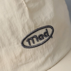 Detailed view of black mad embroidery on beige quick-dry breathable fabric baseball cap
