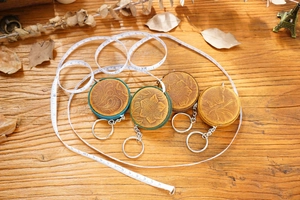 Detailed flat lay of vintage crazy horse leather tape measures on rustic wood background