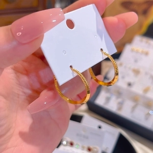 Minimalist 18k gold plated hoop earrings with fine textured surface on display card