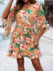Floral print romper with V-neck and ruffled sleeves shown in a poolside setting