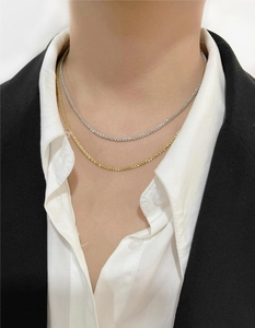Close-up of sparkling gold and silver snowflake chains on a professional model