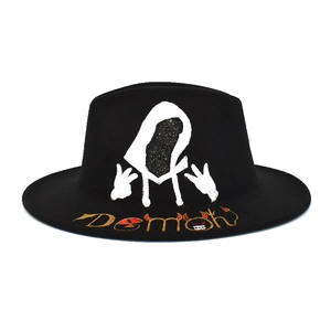 Detail of black wool fedora featuring white hooded figure and Demon graphic text