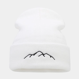 Detailed view of white knitted beanie featuring black mountain range embroidery on cuff