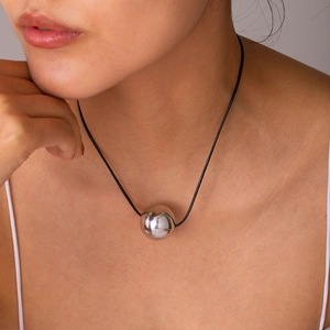 Modern silver spherical pendant necklace on black wax cord shown as worn style