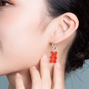 Red transparent gummy bear earring with silver hoop shown on a model's ear